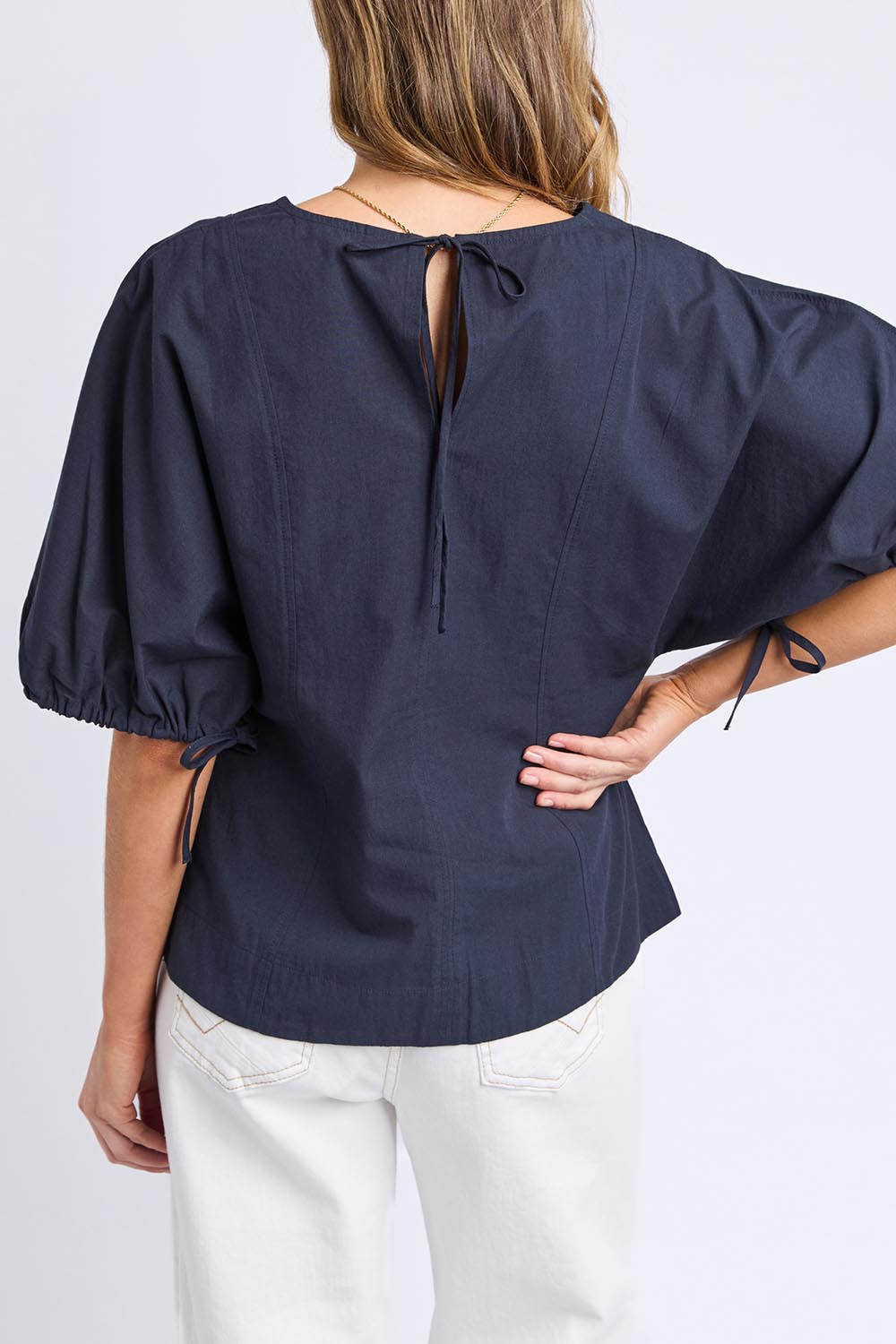A model wearing the Marie Cotton Top in colour Navy (Blue), from the back