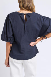 A model wearing the Marie Cotton Top in colour Navy (Blue), from the back