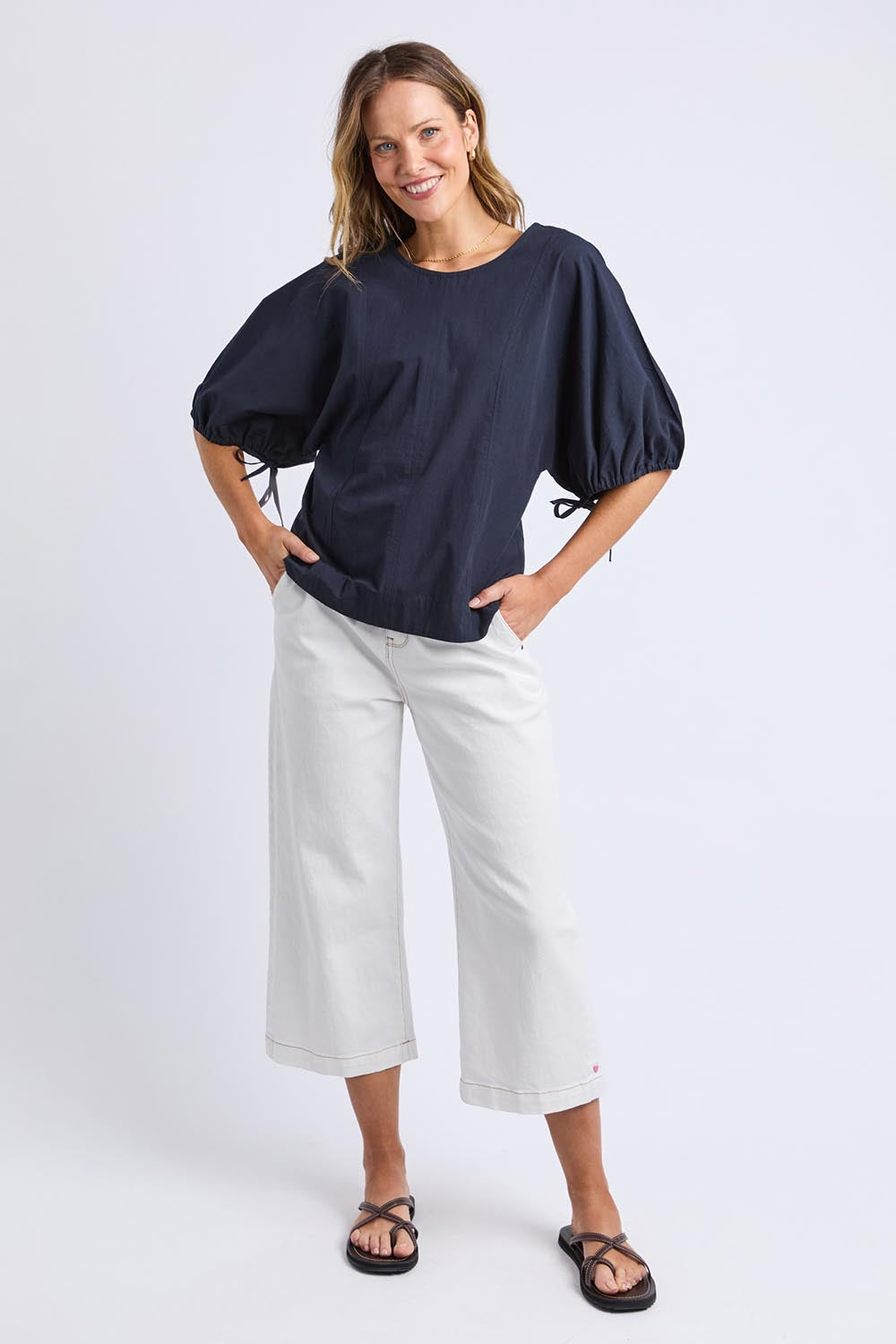 A model wearing the Marie Cotton Top in colour Navy (Blue), from the front, showing the whole outfit