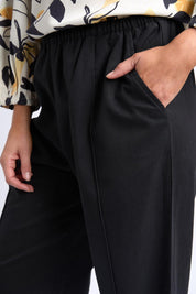 A model wearing the Lucinda Lyocell Cotton Pant in colour Black (Black), from the front, cropped image