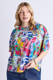 A model wearing the Lala Land Cotton Tee in colour Print, from the front, cropped image