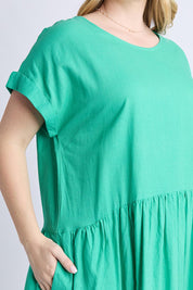 A model wearing the Sunset Hour Linen Blend Dress in colour Gumdrop (Green), from the front, cropped image