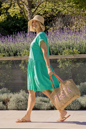 A model wearing the Sunset Hour Linen Blend Dress in colour Gumdrop (Green), from the front, showing the whole outfit