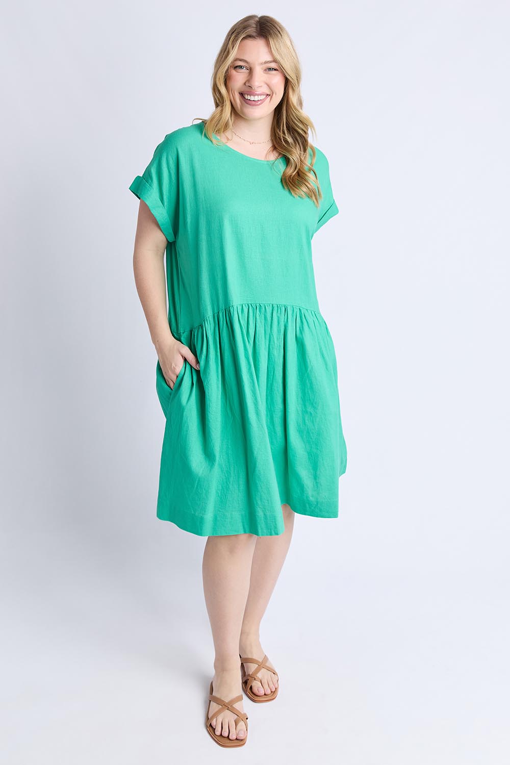 A model wearing the Sunset Hour Linen Blend Dress in colour Gumdrop (Green), from the front, showing the whole outfit