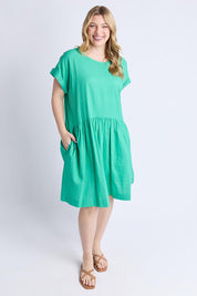 A model wearing the Sunset Hour Linen Blend Dress in colour Gumdrop (Green), from the front, showing the whole outfit