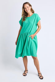 A model wearing the Sunset Hour Linen Blend Dress in colour Gumdrop (Green), from the front, showing the whole outfit