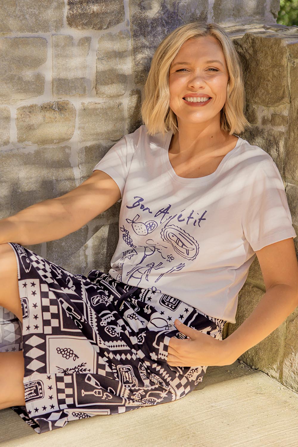A model wearing the Bon Appetit Cotton Tee in colour White (White), from the front, showing the whole outfit