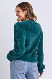 A model wearing the Paris Cardigan in colour Teal (Green), from the back