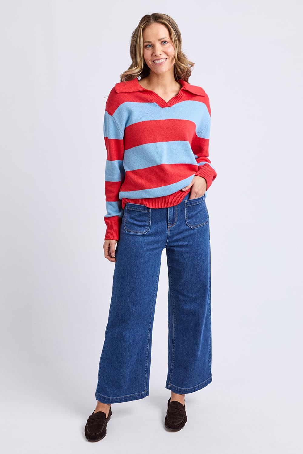 A model wearing the Striped Cotton Polo Knit in colour Brightred, from the front, showing the whole outfit