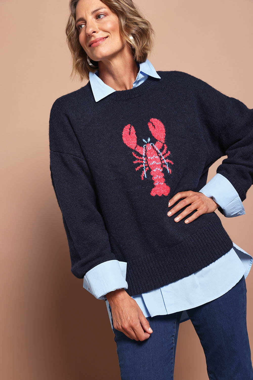 Model Riina wearing size S of the Lobster Intersaid Knit in colour Navy (Blue), from the front, showing the whole outfit