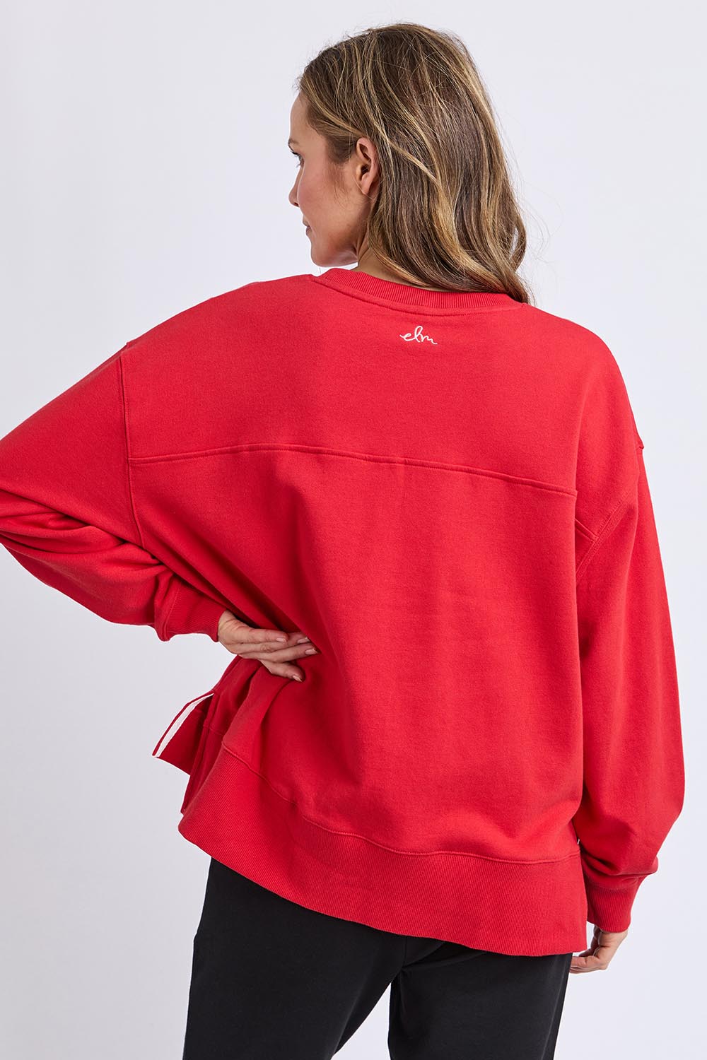 A model wearing the Amelie Crew in colour Cranberry (Red), from the back
