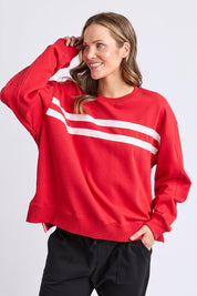 A model wearing the Amelie Crew in colour Cranberry (Red), from the front, cropped image