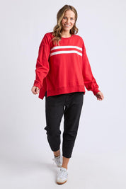 A model wearing the Amelie Crew in colour Cranberry (Red), from the front, showing the whole outfit