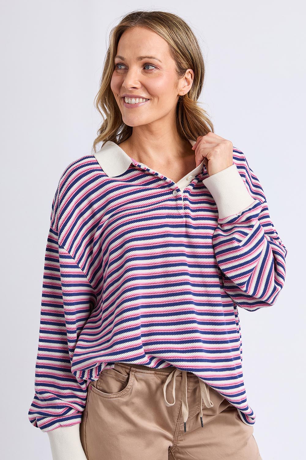 A model wearing the Riviera Polo Sweater in colour Navyred, from the front, cropped image