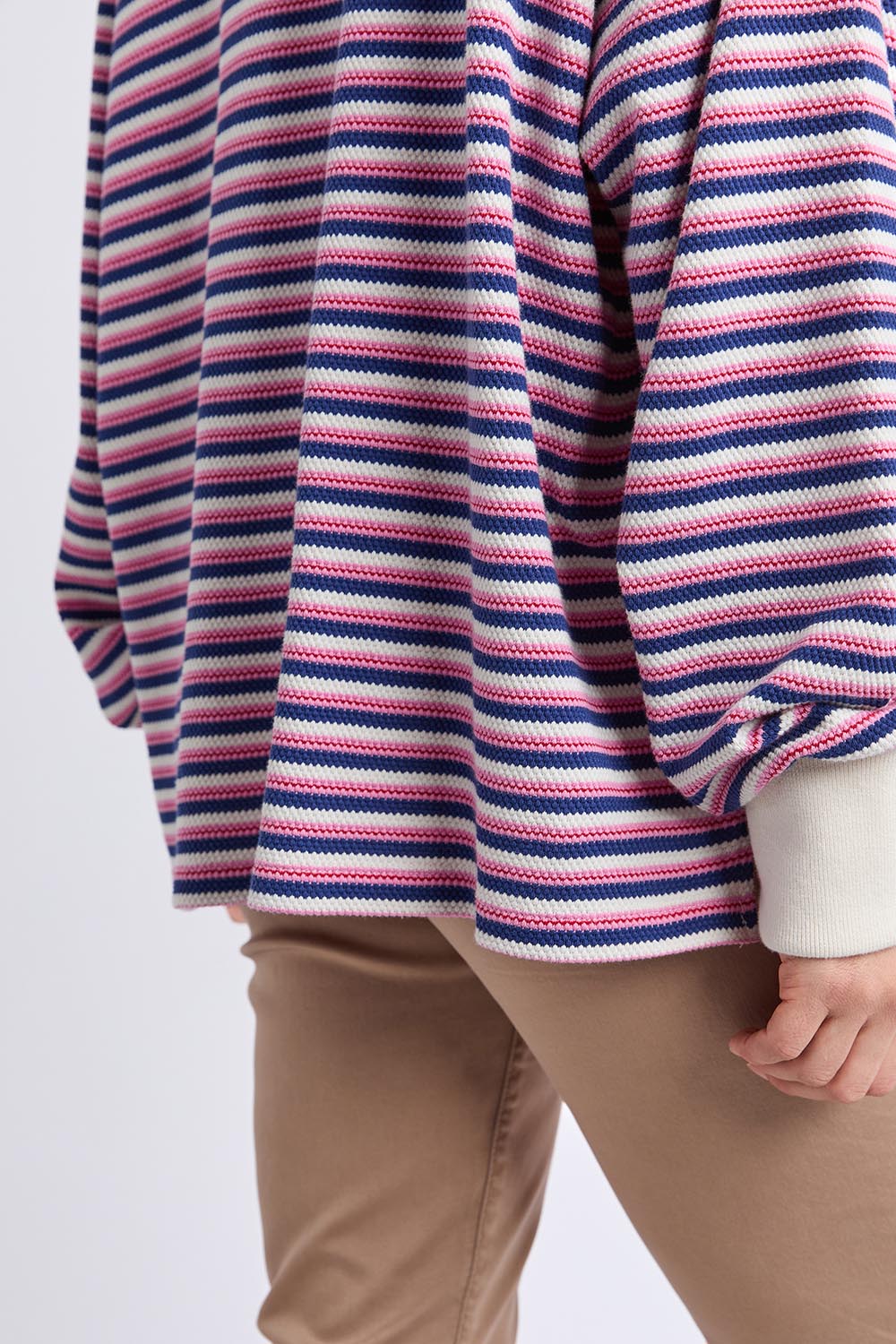 A model wearing the Riviera Polo Sweater in colour Navyred, from the front, cropped image