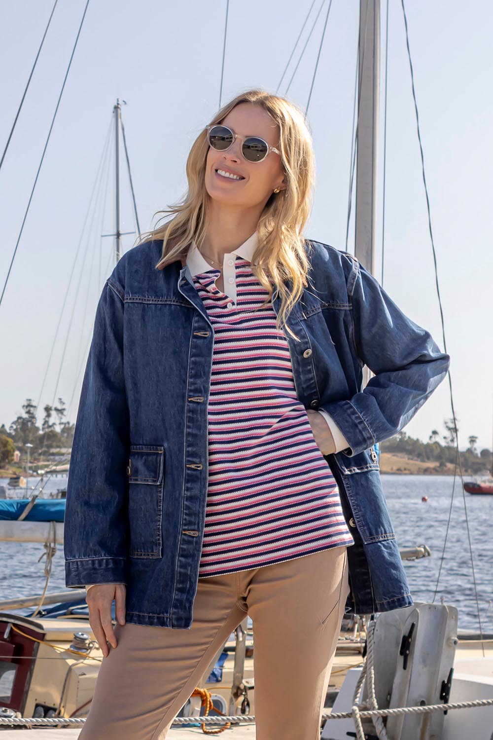 A model wearing the Riviera Polo Sweater in colour Navyred, from the front, showing the whole outfit