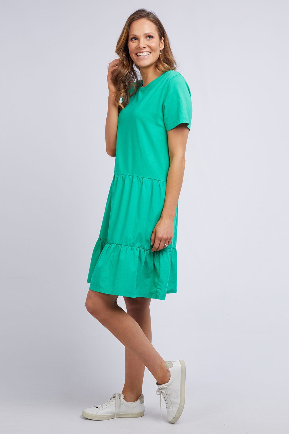 A model wearing the Joanna Tee Dress in colour Green (Green), from the front, showing the whole outfit