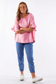 A model wearing the Miranda Top in colour Bubblep (Pink), from the front, showing the whole outfit