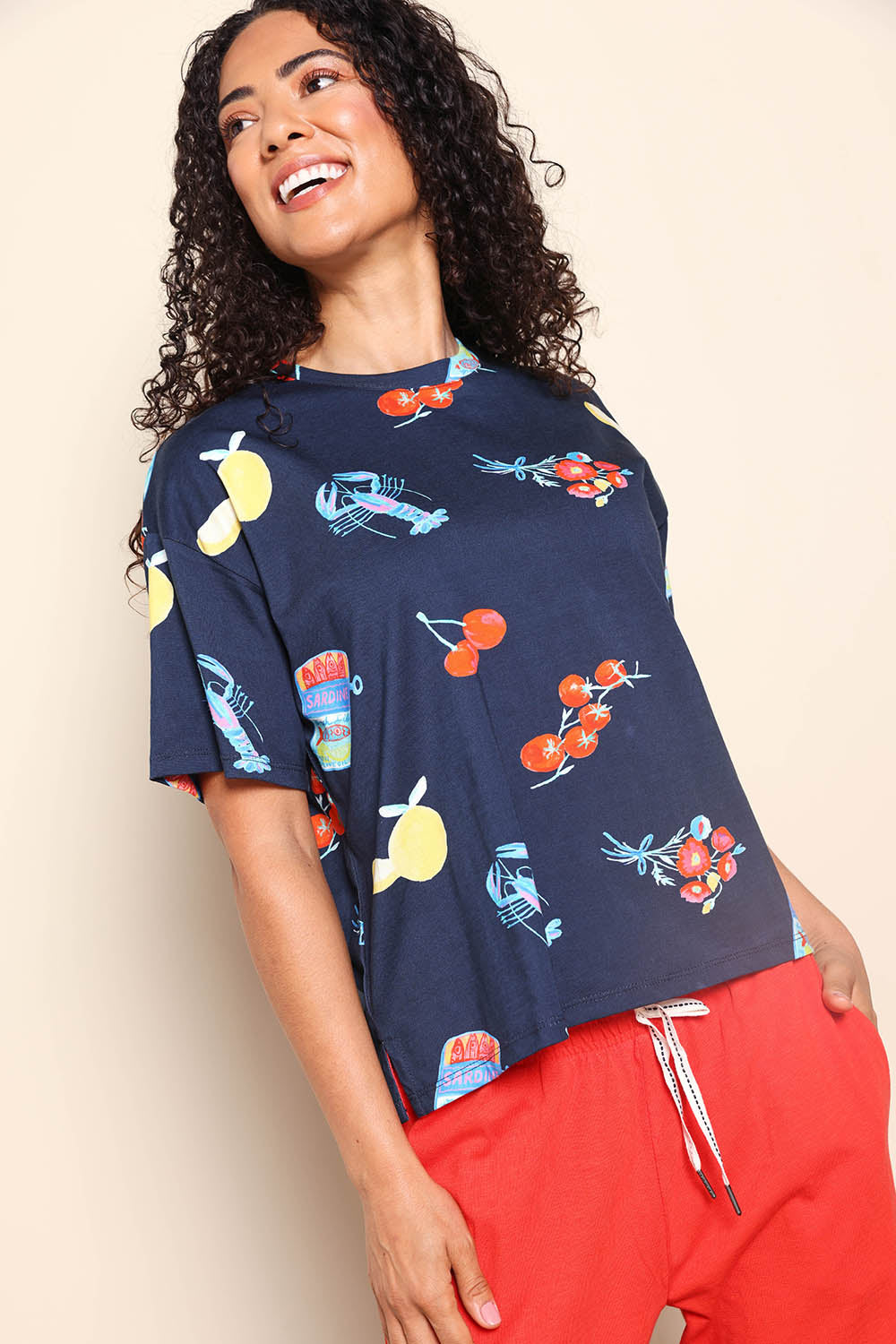 Model Pamelar wearing size 10 of the Market Tee – Navy in colour Navy, from an angle