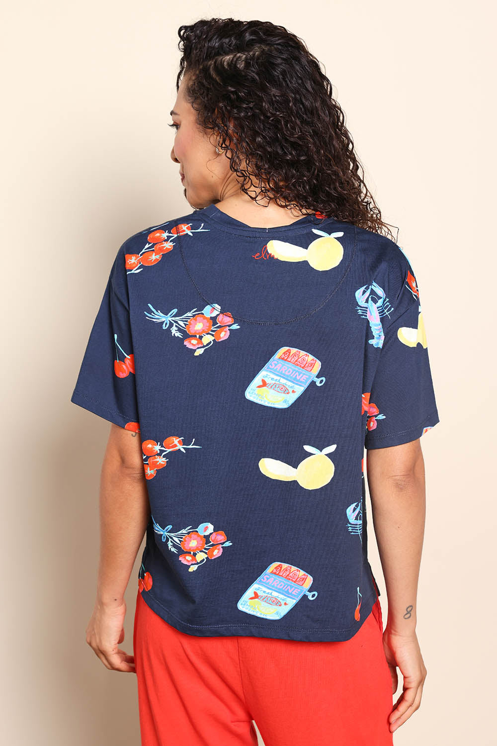 Model Pamelar wearing size 10 of the Market Tee – Navy in colour Navy, from the back