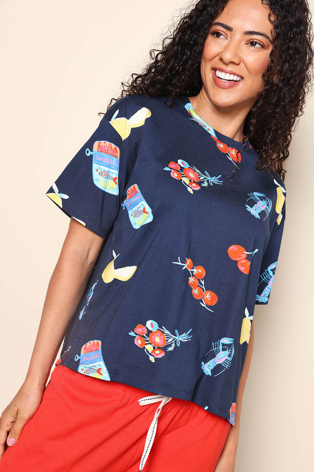 Model Pamelar wearing size 10 of the Market Tee – Navy in colour Navy, in a cropped view