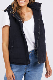 A model wearing the Cord Puffer Vest in colour Dsapphire (Blue), from the front, cropped image