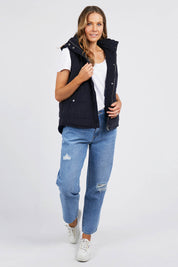A model wearing the Cord Puffer Vest in colour Dsapphire (Blue), from the front, showing the whole outfit
