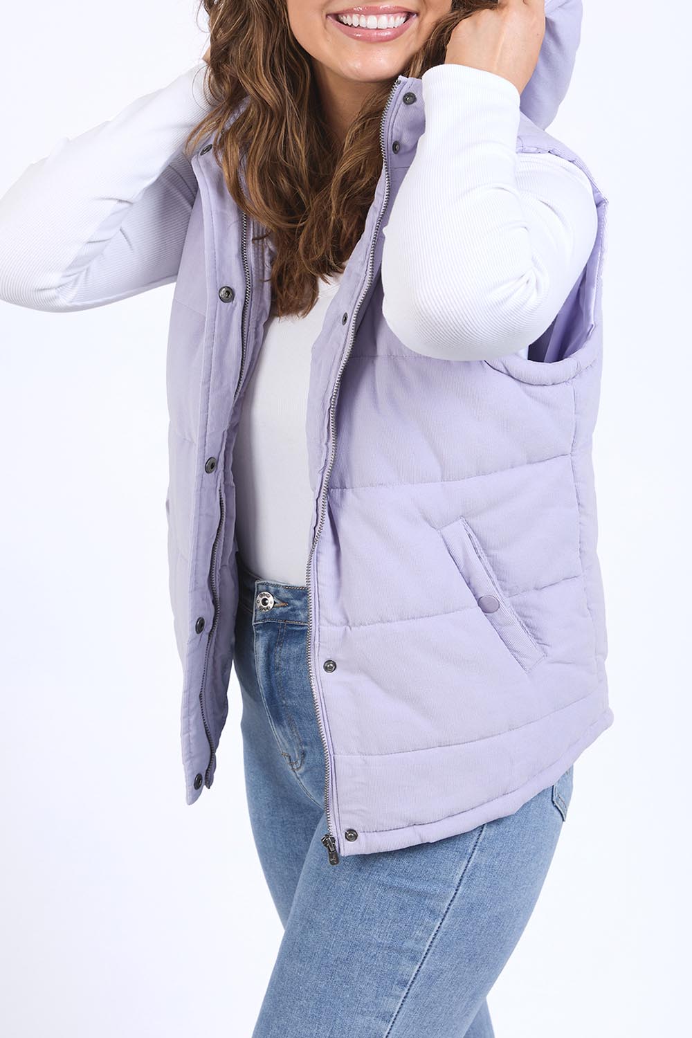 A model wearing the Cord Puffer Vest in colour Dustylila (Purple), from the front, cropped image