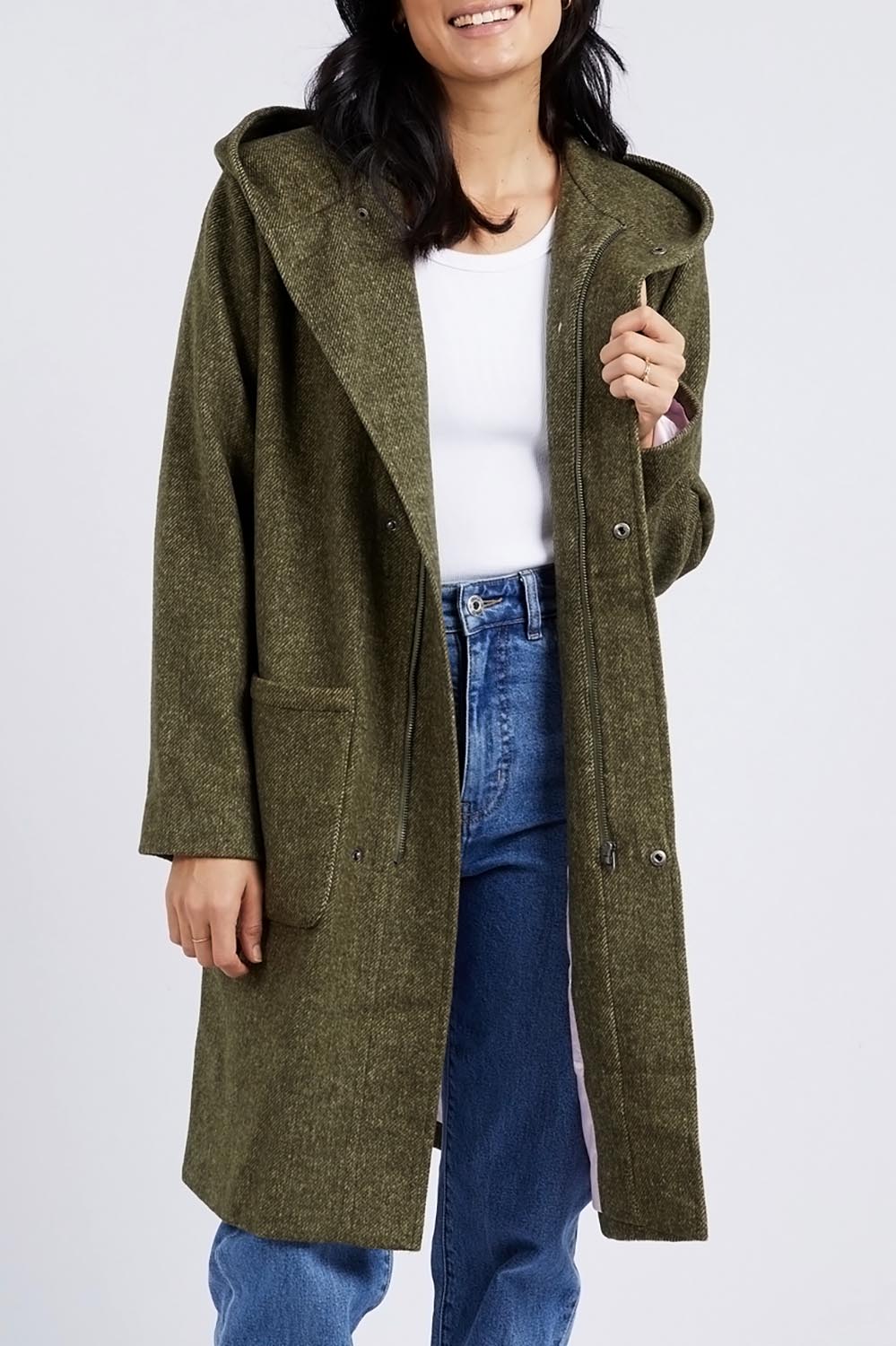 A model wearing the Jordan Coat in colour Clover (Green), from the front, cropped image