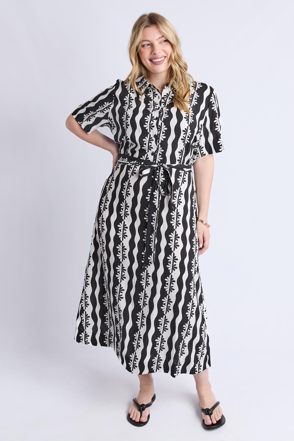 A model wearing the Casa Dress in colour Blackmarsh (Black), from the front, showing the whole outfit