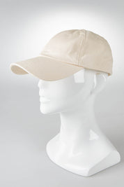 A model wearing size OneSize of the Elm Cap in colour Oatmeal, from the front, showing the whole outfit