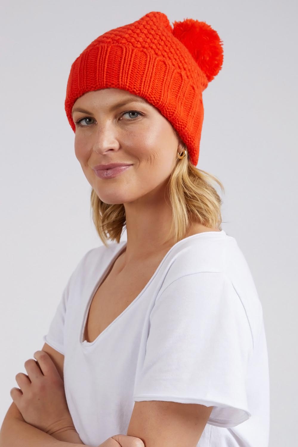 A model wearing the Berry Beanie in colour Tangelo, from the front, showing the whole outfit