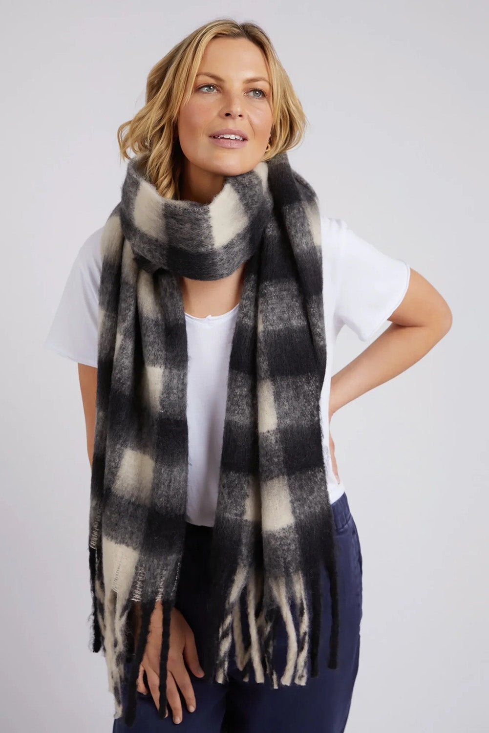 A model wearing the Beth Scarf in colour Check (Black), from the front, showing the whole outfit