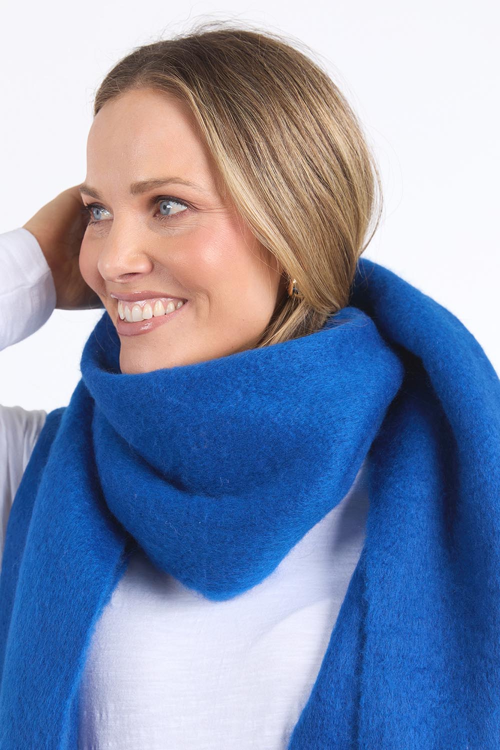 A model wearing the Cosy Scarf in colour Deepblue (Blue), from the front, cropped image