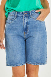 Model Luisa wearing size 10 of the Eden Denim Shorts in colour Denim (Blue), from the front, cropped image