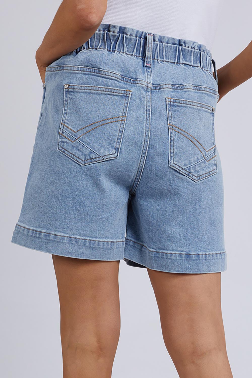 A model wearing the Atlas Denim Shorts in colour Midblue (Blue), from the back