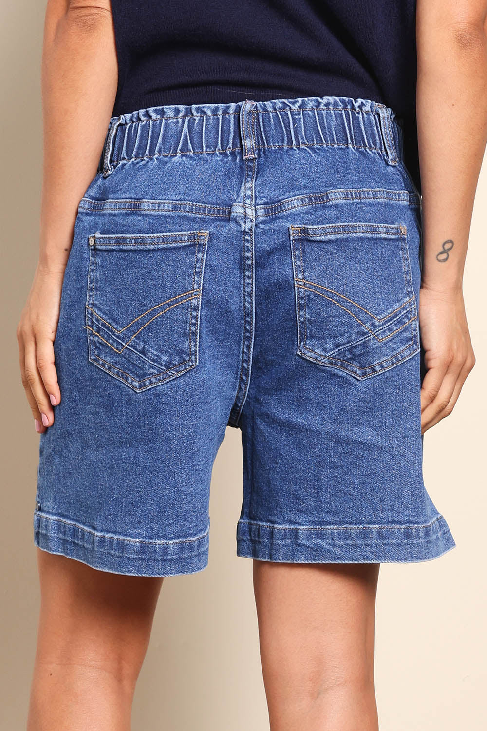 Model Pamelar wearing size 10 of the Fundamental Atlas Denim Short - Darkblue in colour Darkblue, from the back