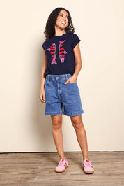 Model Pamelar wearing size 10 of the Fundamental Atlas Denim Short - Darkblue in colour Darkblue, from the front