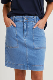 Model Madeline wearing size 10 of the Atlas Denim Skirt in colour Midblue (Blue), from the front, cropped image