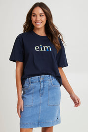 Model Madeline wearing size 10 of the Atlas Denim Skirt in colour Midblue (Blue), from the front, cropped image