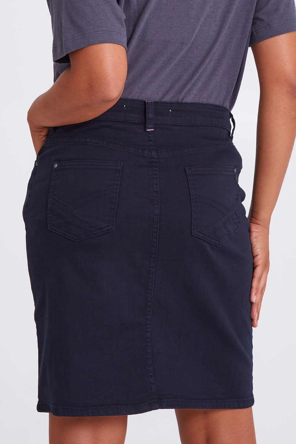Model Olivia wearing size 10 of the Belle Denim Skirt in colour Washeblack (Black), from the back