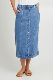 Model Madeline wearing size 10 of the Florence Button Through Skirt in colour Midblue (Blue), from the front, cropped image