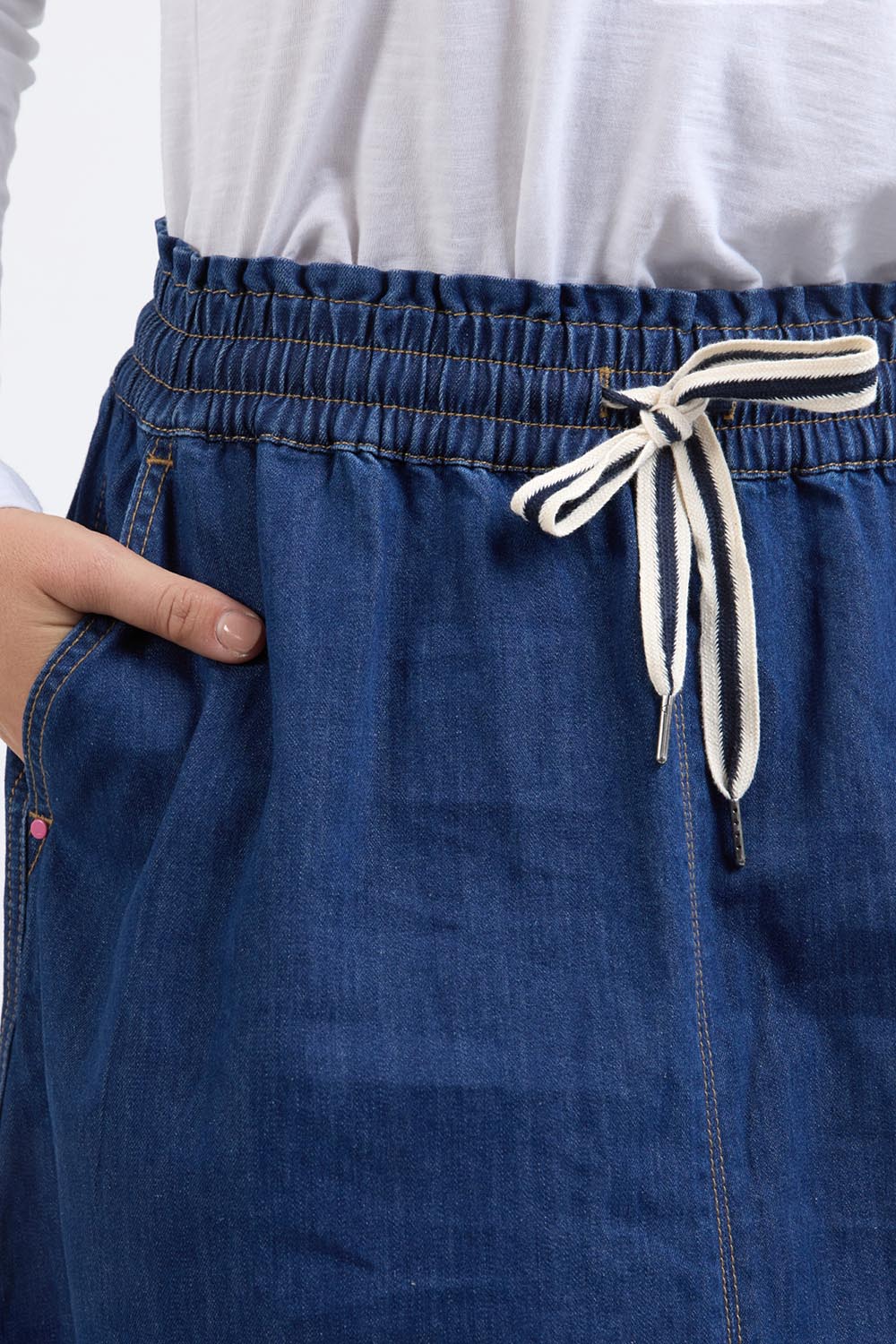 A model wearing the Fundamental Greta Denim Skirt in colour Darkblue (Blue), from the front, cropped image