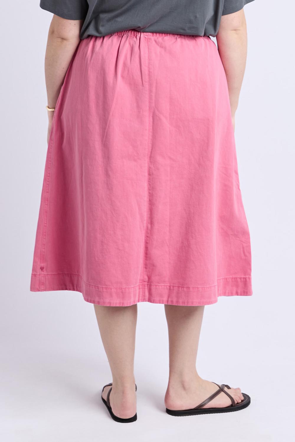 A model wearing the Greta Denim Skirt in colour Chateauros (Pink), from the back