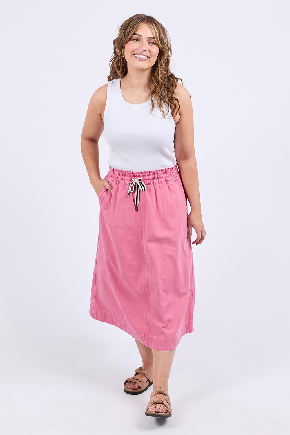 A model wearing the Greta Denim Skirt in colour Chateauros (Pink), from the front, showing the whole outfit