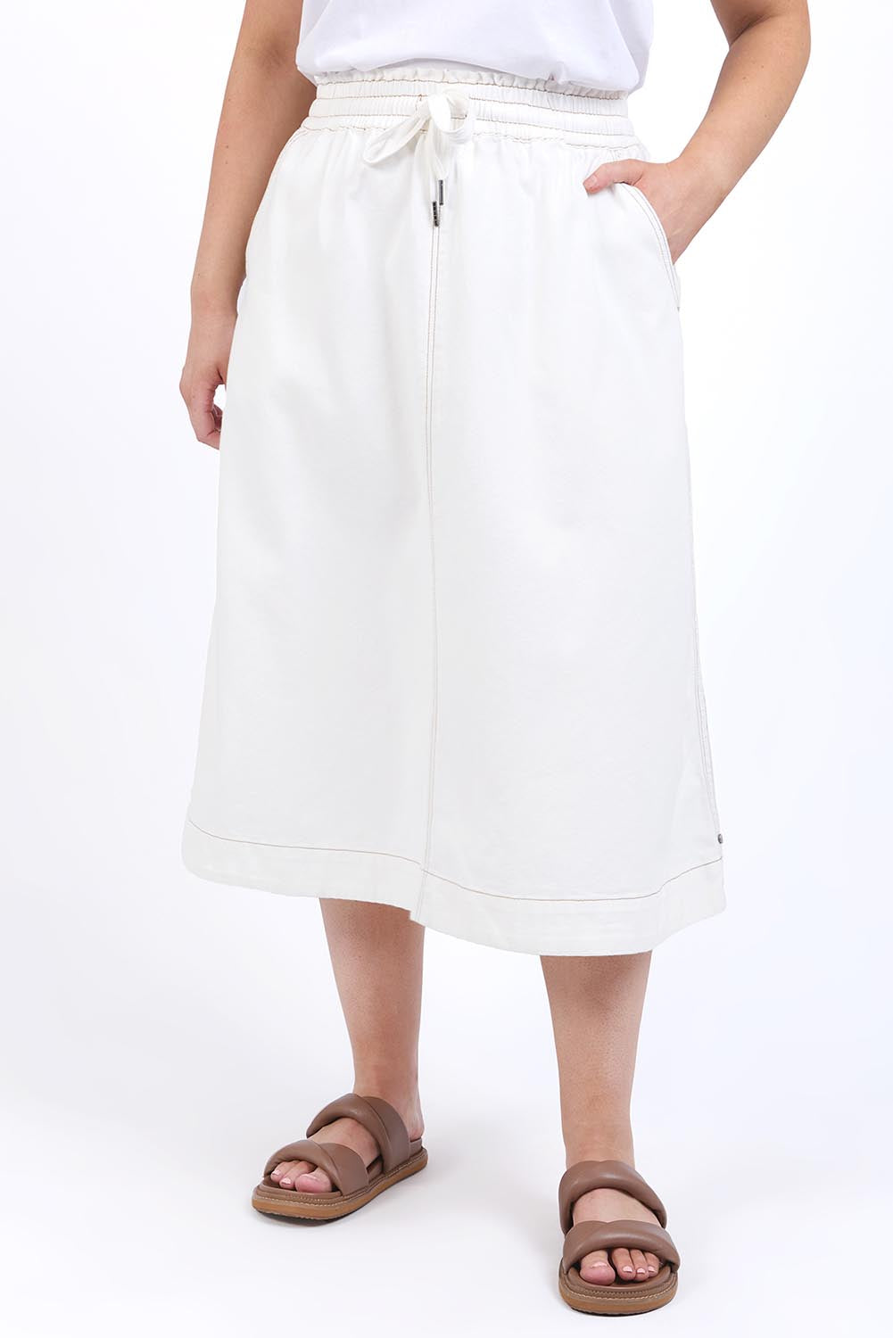 A model wearing the Fundamental Greta Denim Skirt in colour Vintgwhite (White), from the front, cropped image