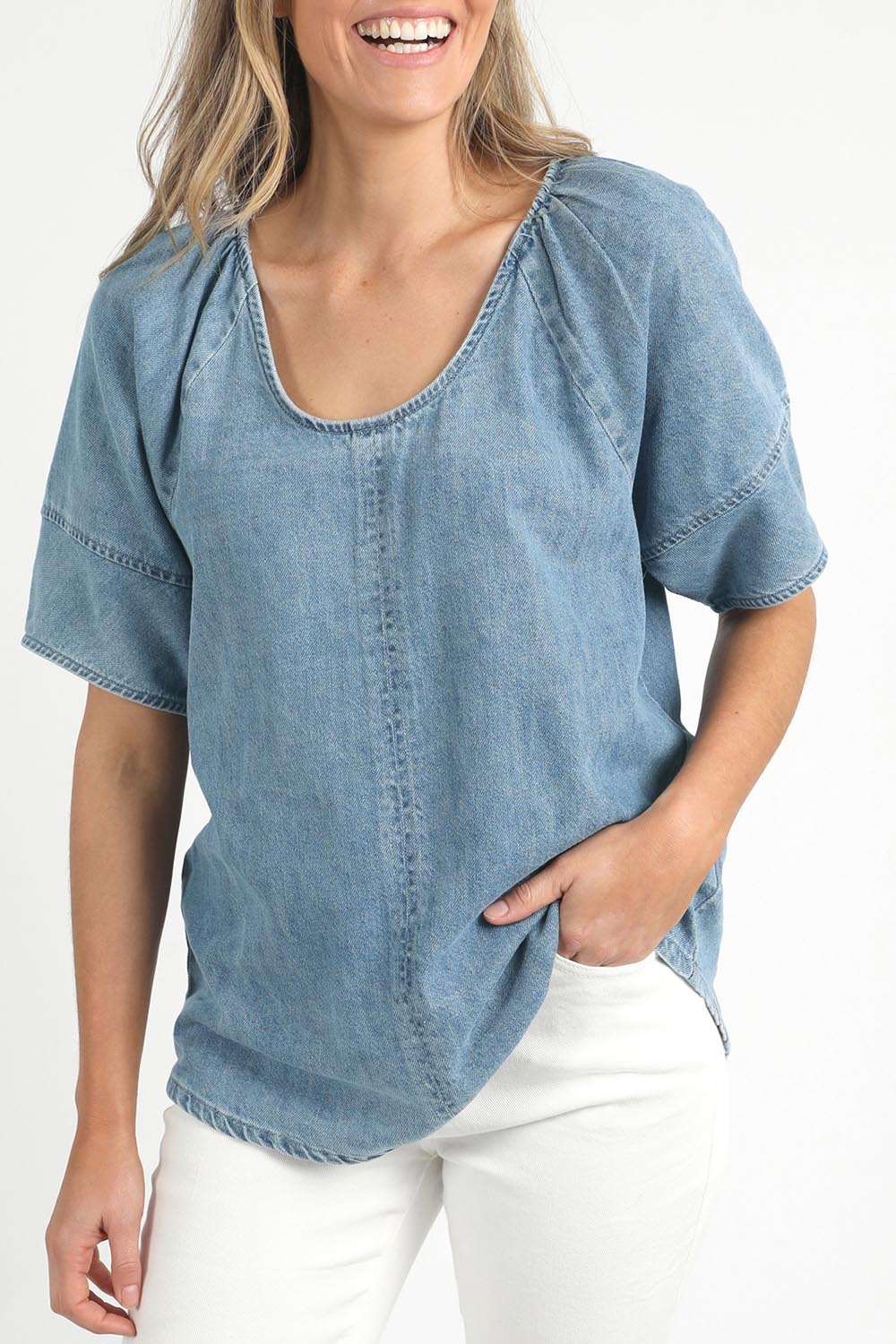 A model wearing the Brea Top in colour Bluewash (Blue), from the front, cropped image