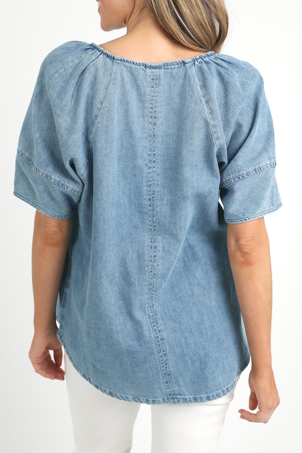 A model wearing the Brea Top in colour Bluewash (Blue), from the front, cropped image