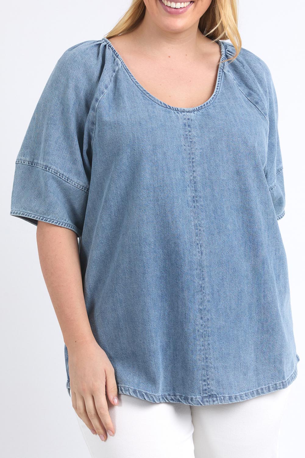 A model wearing the Brea Top in colour Bluewash (Blue), from the front, cropped image