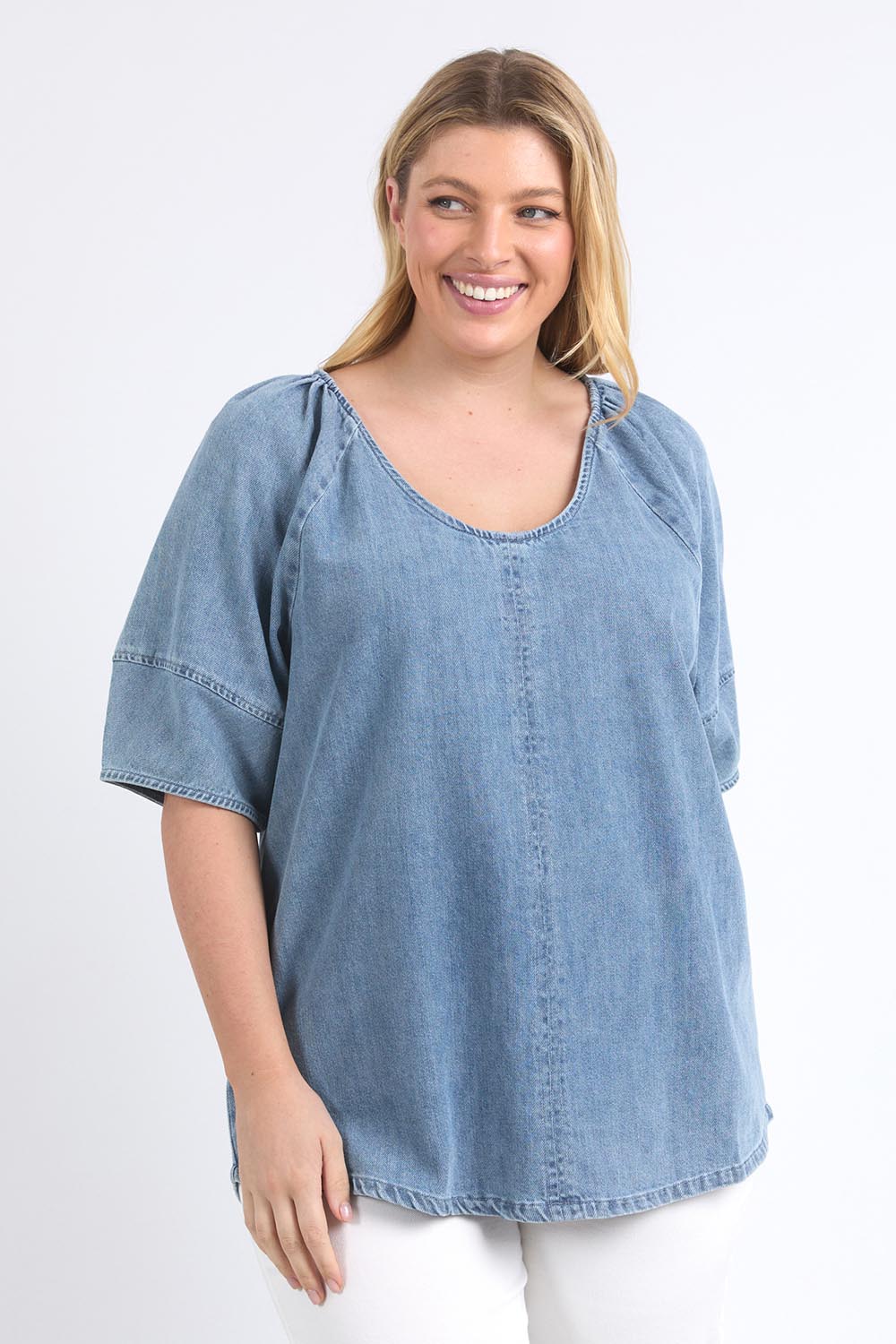 A model wearing the Brea Top in colour Bluewash (Blue), from the front, cropped image